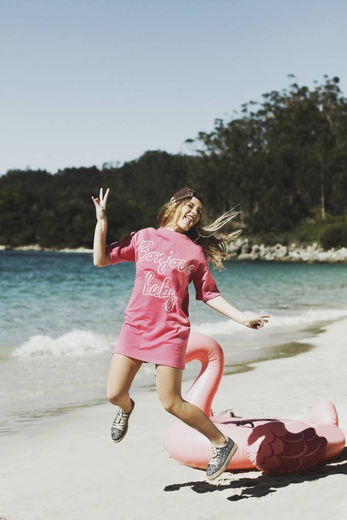 look de verano para mujer con camiseta rosa larga y deportivas krack brillantes con purpurina