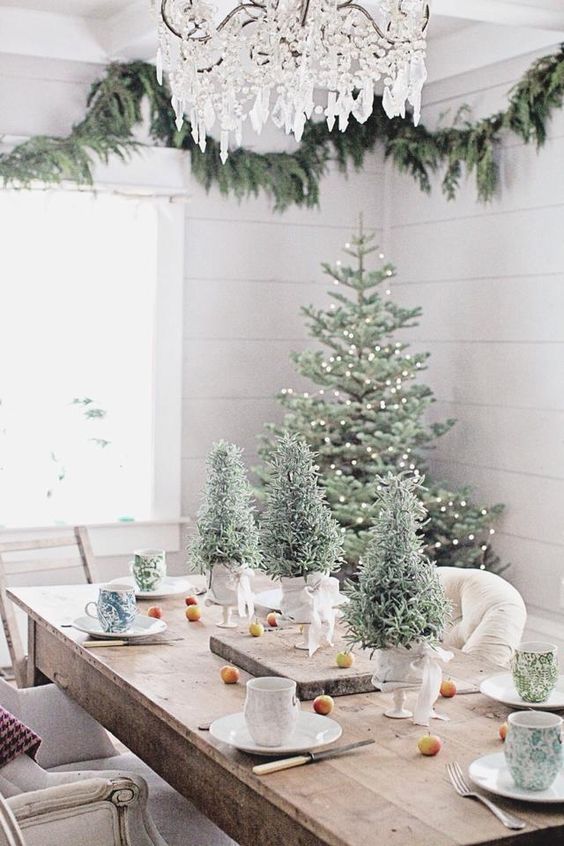 mesa decorada navidad con pinos con nieve y luces decorativas diciembre